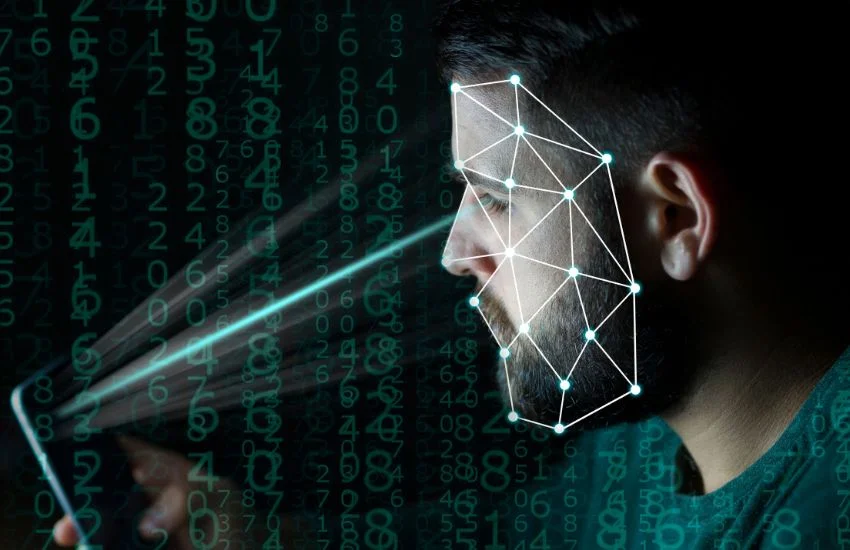 Hombre utilizando sistema de reconocimiento facial mediante dispositivo móvil, con representación digital de puntos biométricos y cifras numéricas en segundo plano